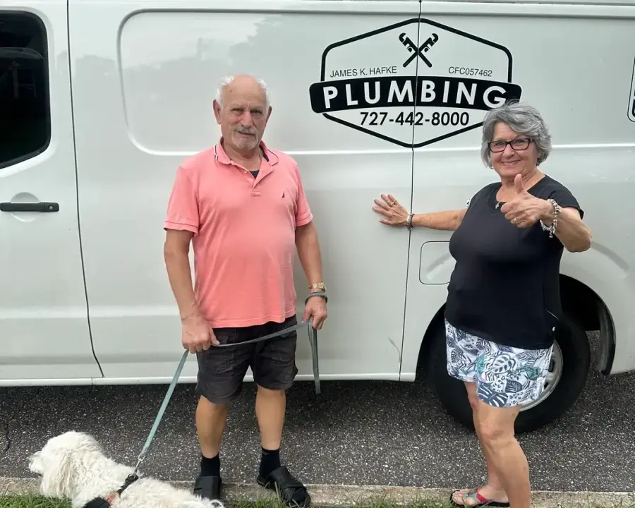 The Hafke family and their dog beside a branded James K. Hafke Plumbing service van in St. Petersburg